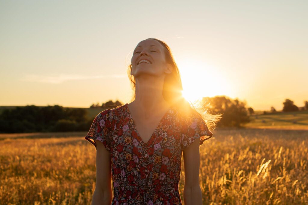 Woman embracing sunlight in an open field